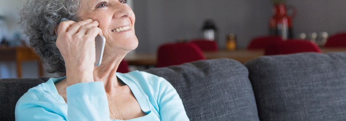 Senior à domicile utilisant un service de téléassistance avec bracelet d’alerte