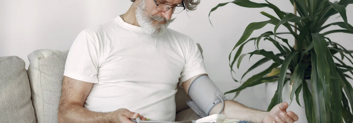 Senior prenant sa tension artérielle à domicile avec un tensiomètre électronique