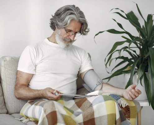 Senior prenant sa tension artérielle à domicile avec un tensiomètre électronique