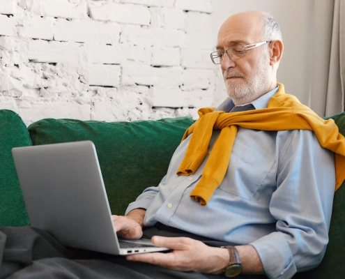 Senior vérifiant un email suspect pour éviter une tentative de fraude