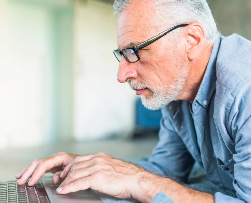 Senior vérifiant les indices d’un faux site de vente avant de commander