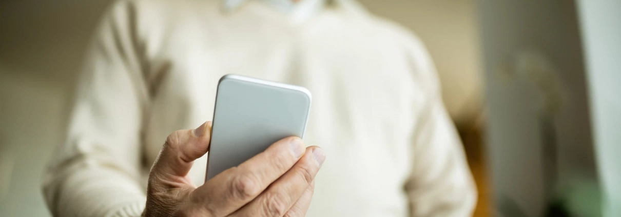 Smartphone affichant un SMS frauduleux à repérer et signaler
