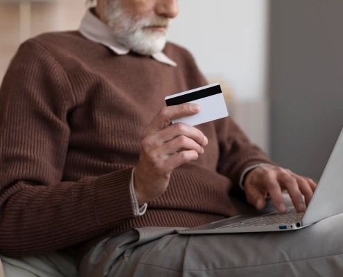 Senior utilisant sa carte bancaire sur Internet en vérifiant la sécurité du paiement