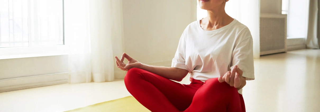 Senior pratiquant une séance de yoga sur chaise à domicile