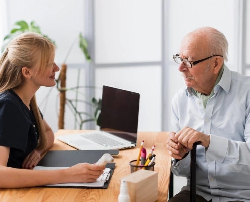 Senior accompagné par une conseillère pour comprendre simplement son contrat d’assurance